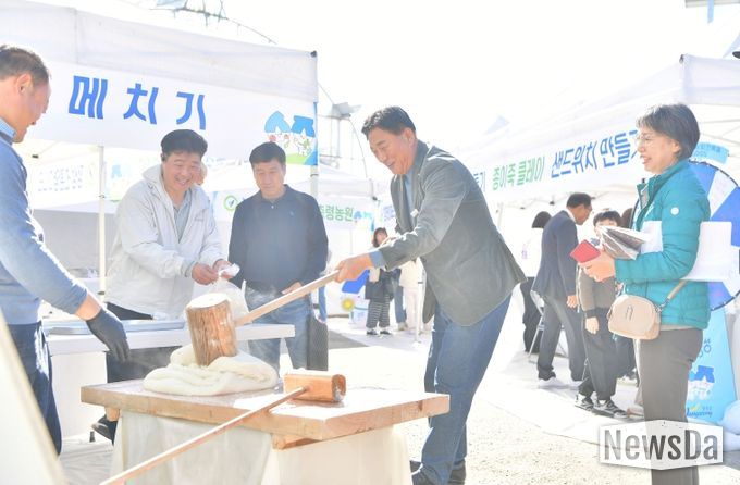 지난 15일 황룡면 팜파티 현장을 방문한 김한종 장성군수가 떡메치기 체험을 하고 있다.