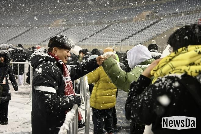 부천FC1995의 승강 PO 1차전이 폭설로 연기된 후 돌아가는 시민들과 조용익 부천시장이 주먹인사를 나누고 있다.