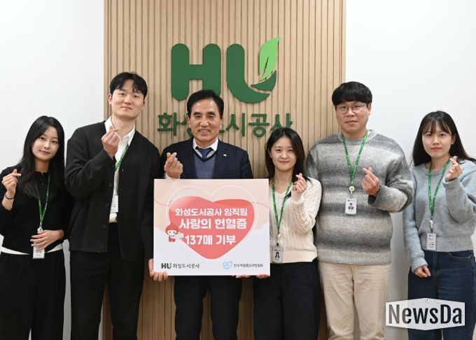 화성도시공사 한병홍 사장이 임직원들이 자발적으로 기부한 헌혈증 전달을 알리는 판넬을 들고 기념촬영을 하고 있다.