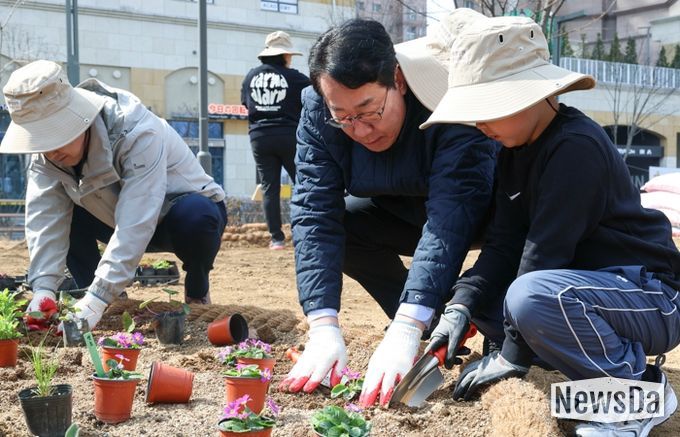 정명근 화성특례시장(가운데)이 21일 동탄여울공원에서 화성특별정원에 아이와 함께 꽃을 심고 있다